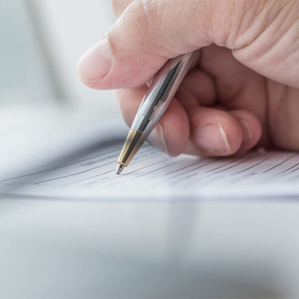 Close up of person signing a document