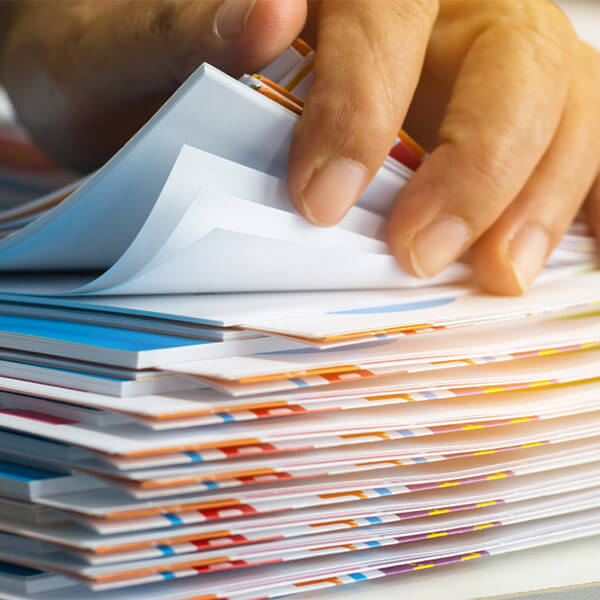 Hand sorting through a stack of documents